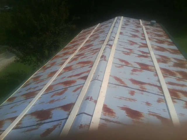 Rusted metal roof panels with new wood purlins before replacement — Storm Damage Roof Repair in Terra Alta by Roofing Brothers
