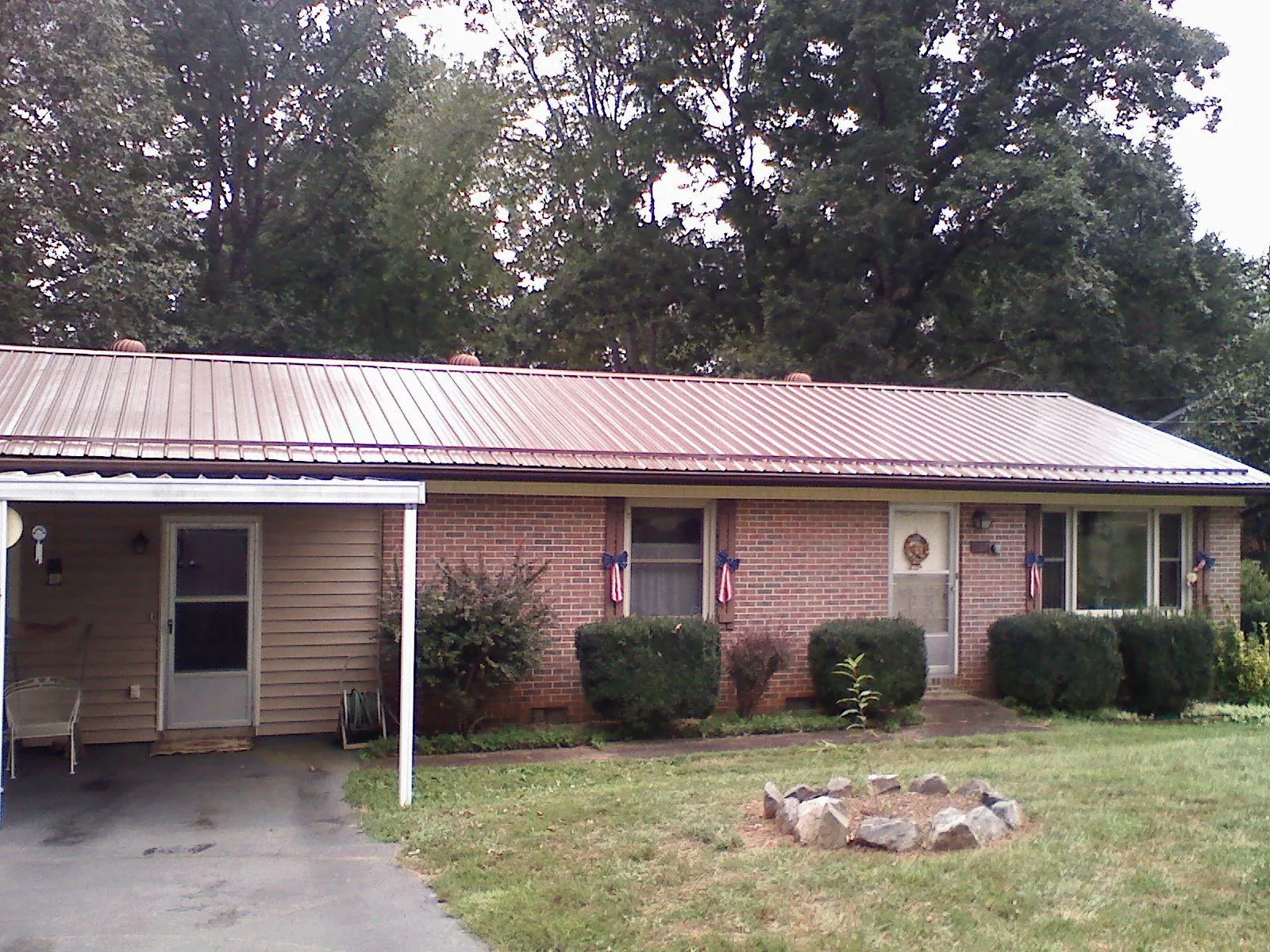 Bronze metal roof and carport on a brick ranch home — Roof Repair work by our crew in Terra Alta