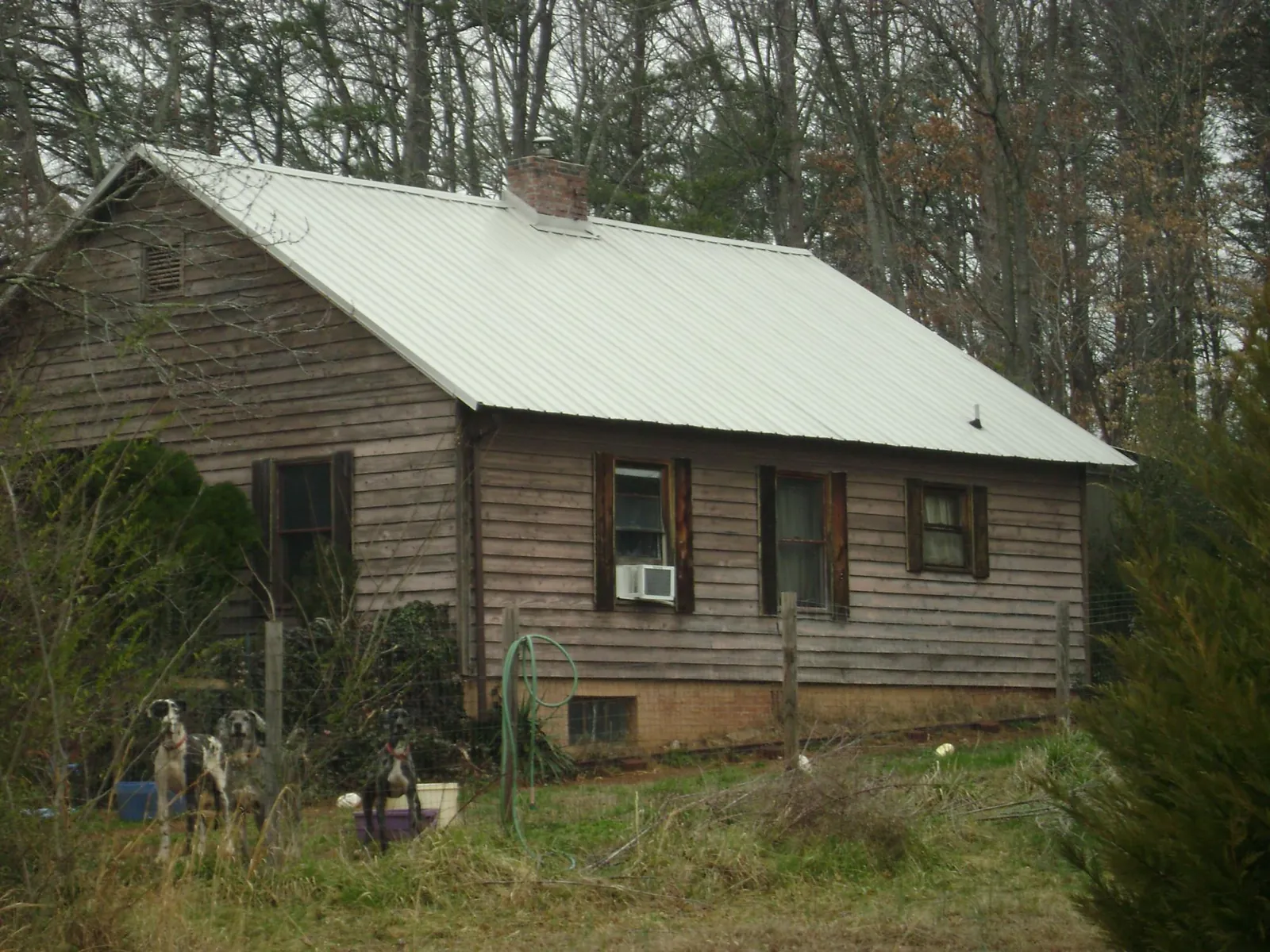 White metal roof on an old wood sided farmhouse, from a Metal Roof Installation job in Terra Alta
